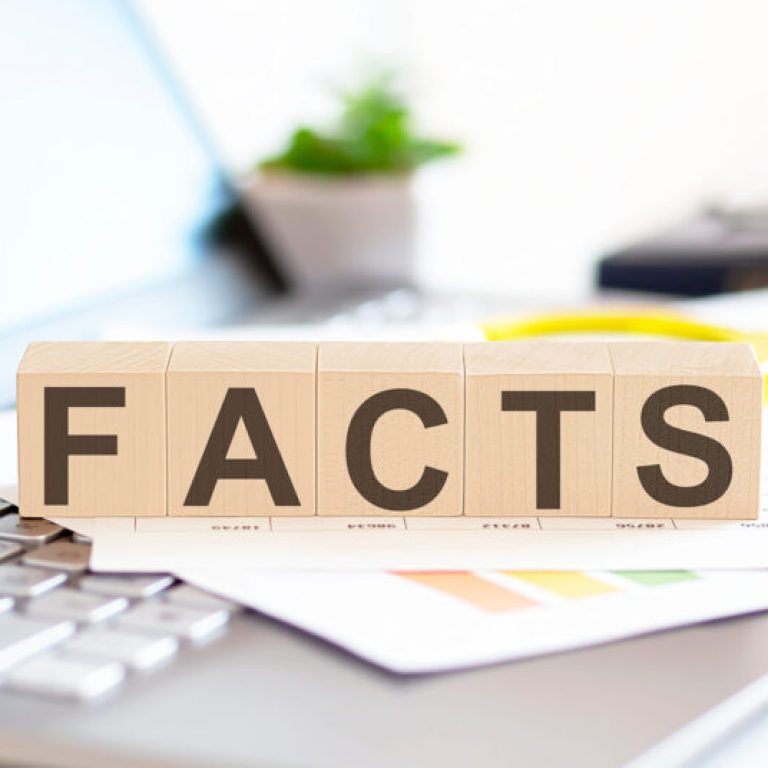 FACTS Wooden cubes with letters on a laptop keyboardwith charts , magnifier