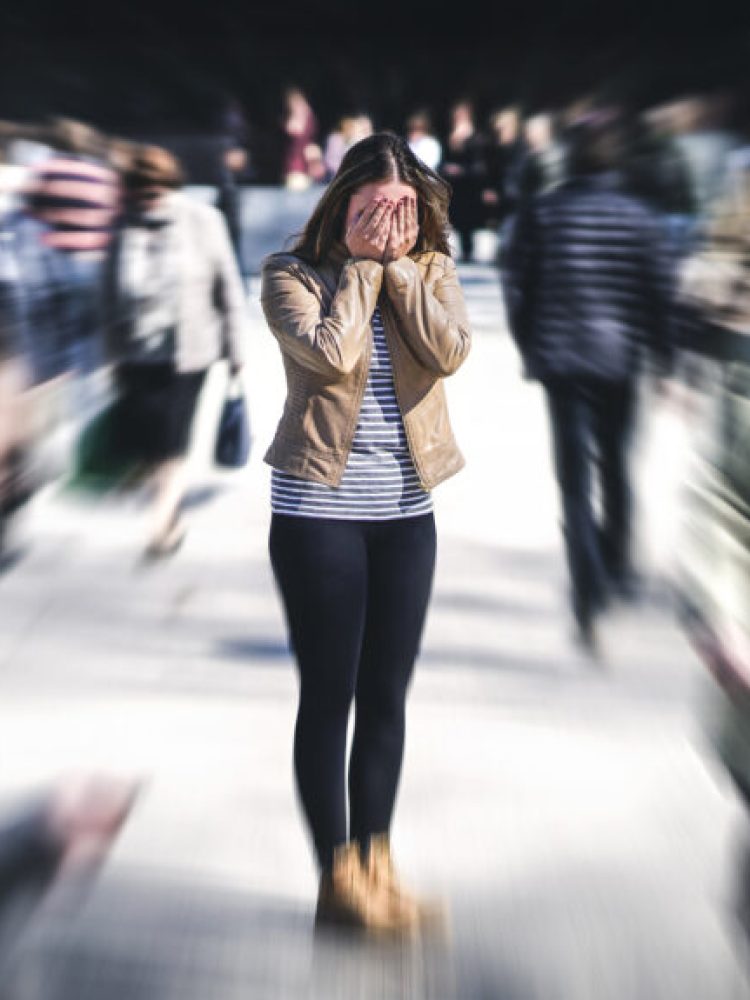 Panic attack in public place. Woman having panic disorder in city. Psychology, solitude, fear or mental health problems concept. Depressed sad person surrounded by people walking in busy street.