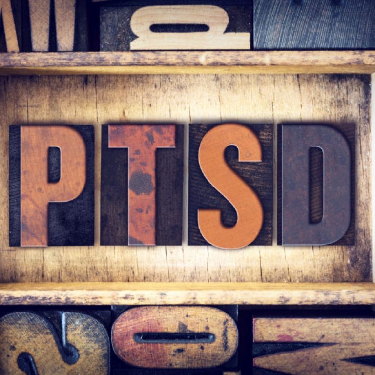 The word "PTSD" written in vintage wooden letterpress type.